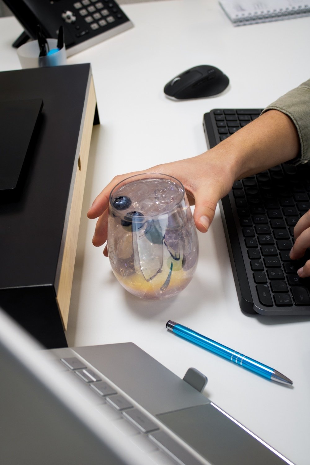 Glas frisdrank op bureau met hand